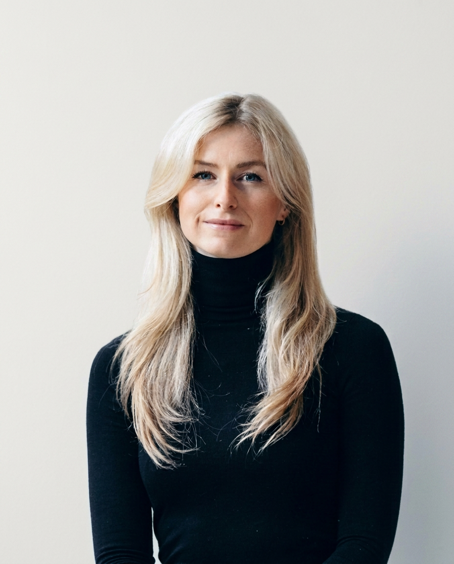Portrait of founder Katharina Man in a black roll-neck, photographed against a plain warm neutral wall